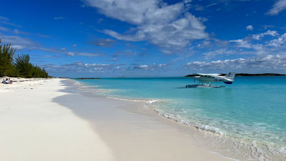 A seaplane anchored in turquoise Bahamian waters