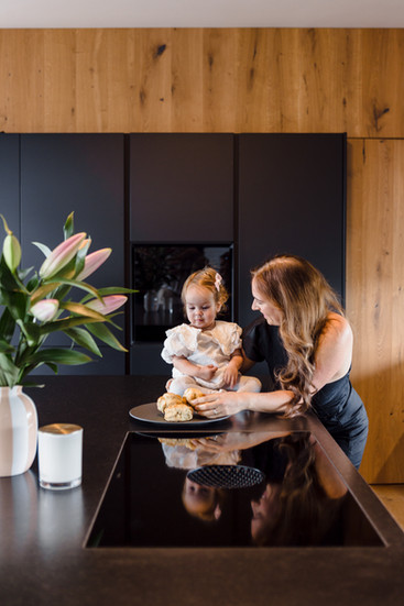 Mutter und Tochter in moderner schwarzer Küche