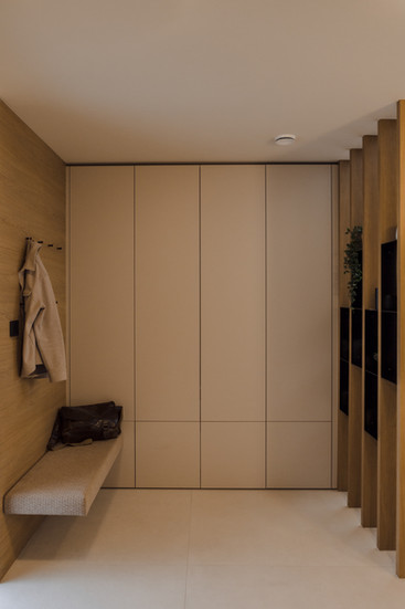 Minimalistischer Eingangsbereich mit warmem Holz, klaren Linien und ruhiger, eleganter Atmosphäre.