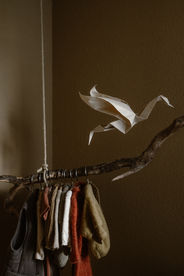 Large origami bird folded from handmade paper, hanging in a nursery