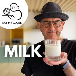 Simon Majumdar holding a glass of milk. Also includes the word, “Milk,” and the Eat My Globe logo of Simon Majumdar's likeness using the initials "S" and "M" holding a globe on a platter with the words, "Eat My Globe," underneath.