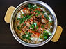 A bowl of lamb stew over an eggplant dip