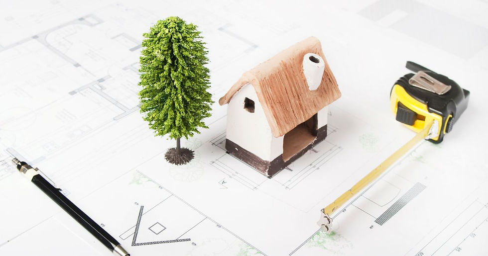 Sobre a mesma ,uma Planta de um projeto arquitetônico, uma caneta, uma trena, uma miniatura de uma casa e uma miniatura de uma árvore