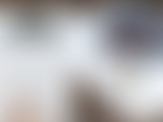 a person holding calculator behind him is a model of the house along with money and paper work and pen