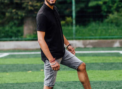 a man on a football field standing with one leg on the football