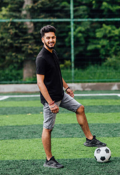 a man on a football field standing with one leg on the football
