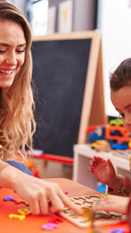 a kindergarten teacher helping a child learn through puzzles