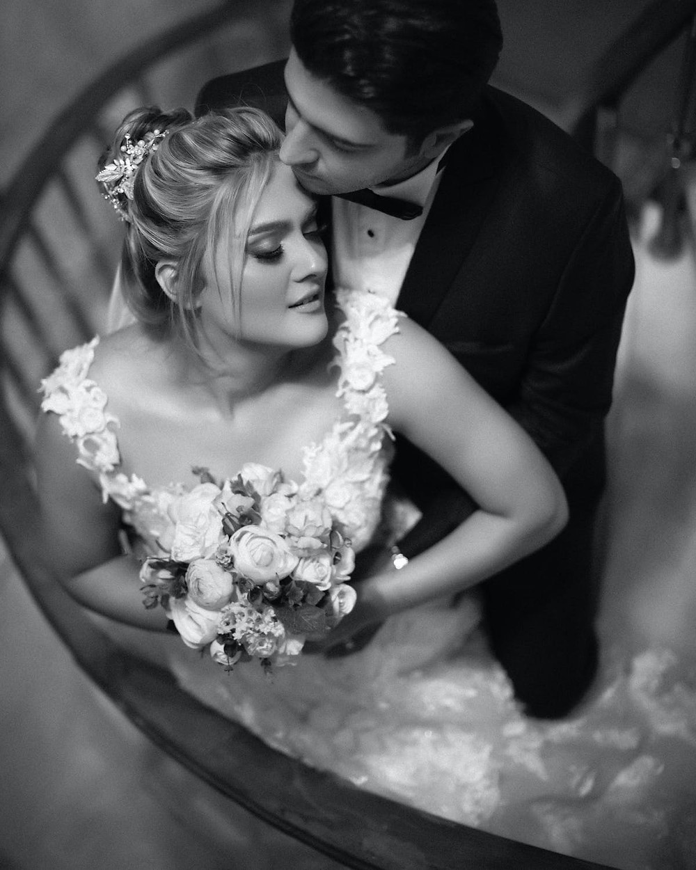 Newlyweds posing for a photo on a spiral staircase
