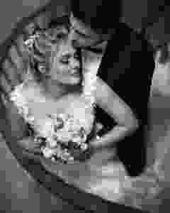 Newlyweds posing for a photo on a spiral staircase