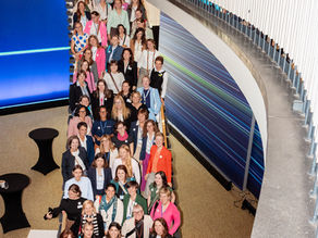 Großes Gruppenfoto des Women in Mobility Luncheons auf der InnoTrans 2026. Zahlreiche Teilnehmerinnen stehen auf einer geschwungenen Treppe über mehrere Etagen verteilt, lächeln in die Kamera