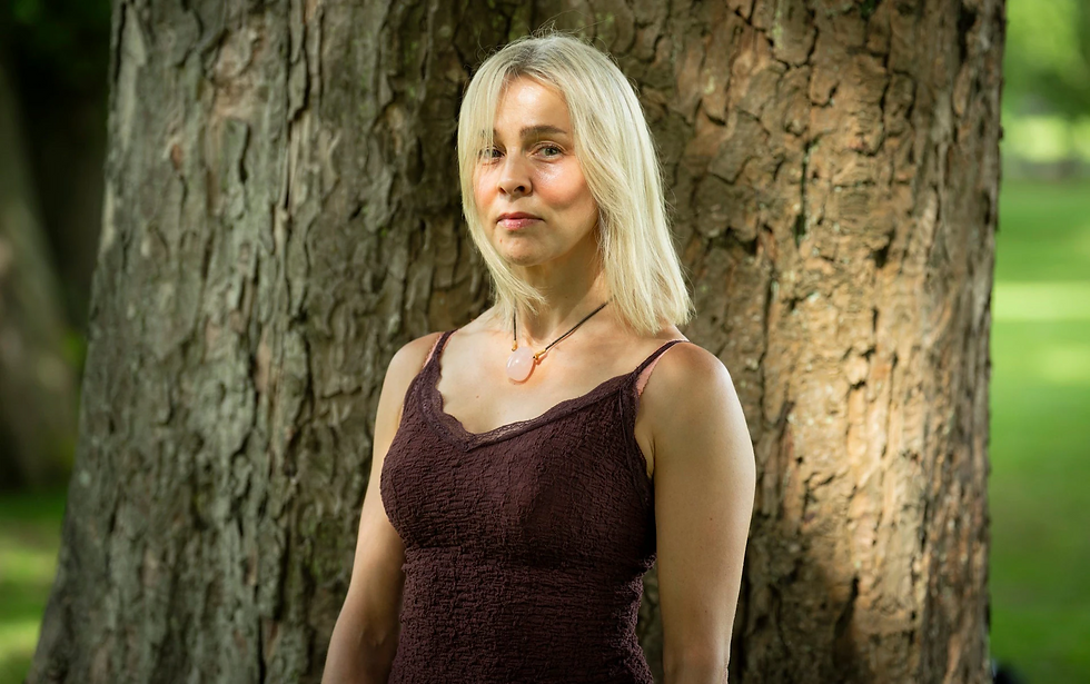 Una donna vicina a due alberi
