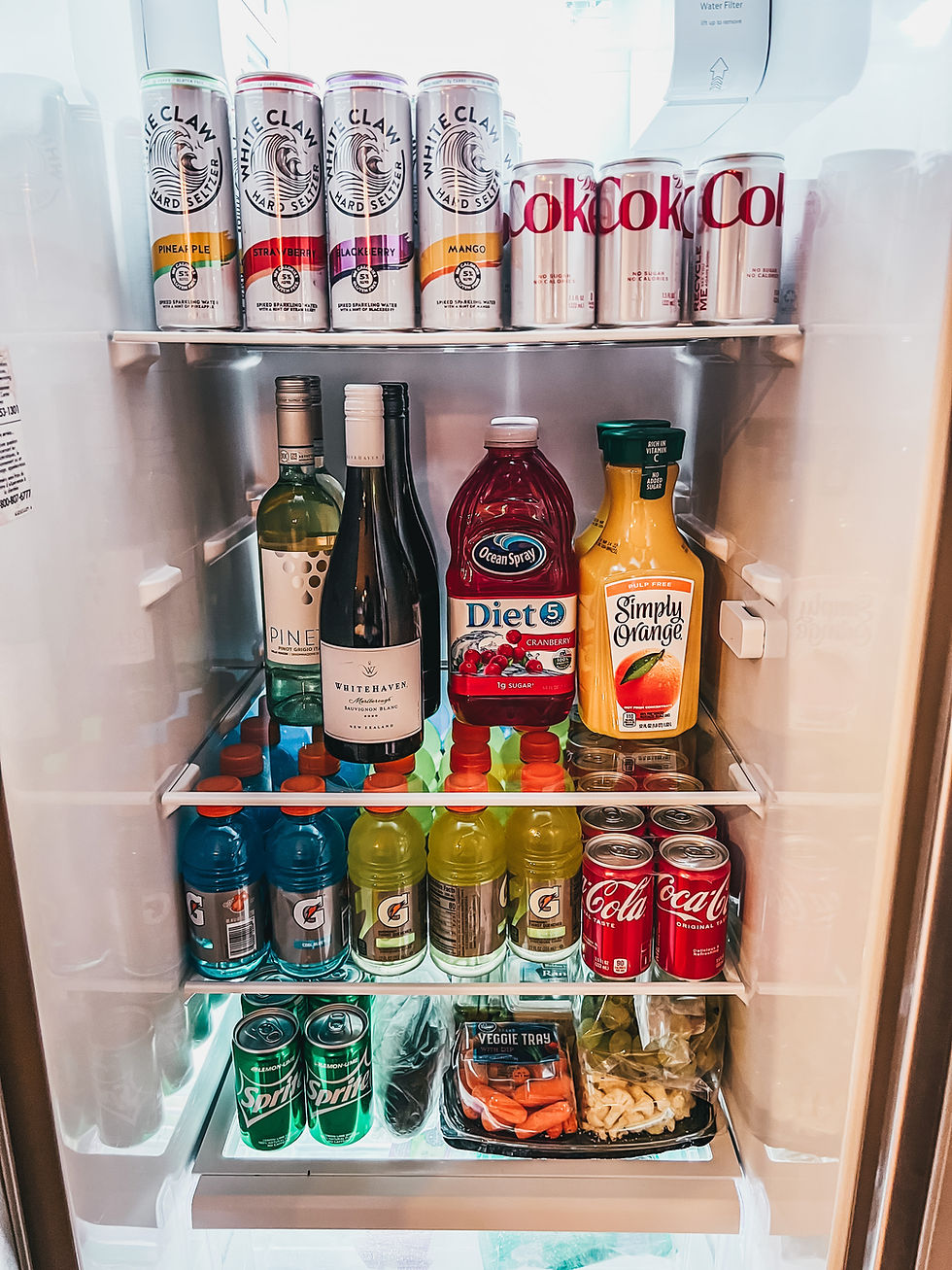 Full refrigerator stocked with drinks and snacks