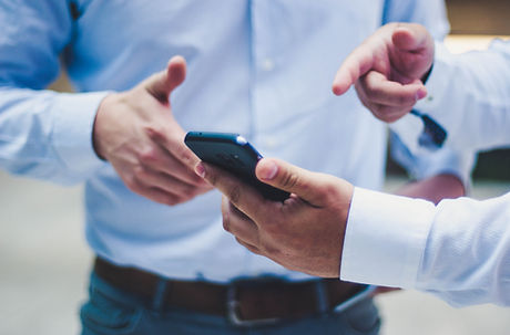 Duas pessoas conversando sobre informaçãos sendo visualizadas em um celular.
