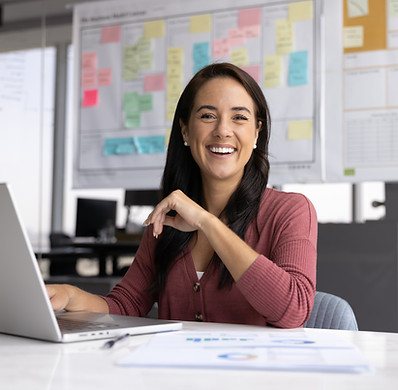 Cheerful woman sit at desk in professional, modern office, smile at camera while using lap