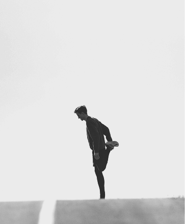 Distant shot of a runner stretching on an outdoor track