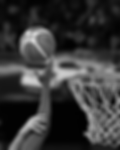 Basketball player’s arm blocking a shot as the ball approaches the hoop.