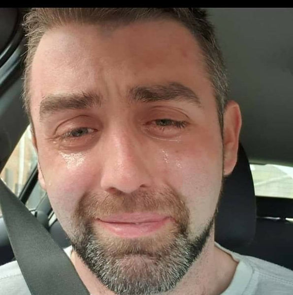 Man driving with tears in his eyes