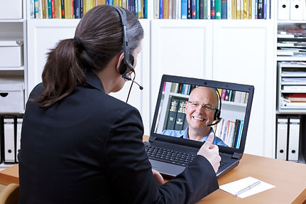 Female attorney-at-law with headset in front of a laptop on her desk giving online advice