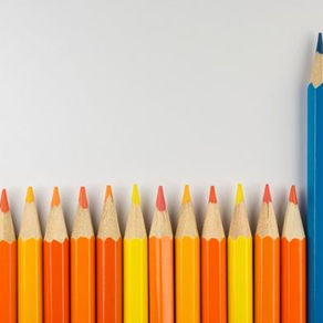 A group of orange pencils with one tall blue pencil standing out, symbolizing leadership and distinction