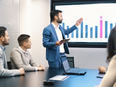A leader presenting data analysis to the team using a bar chart during a meeting