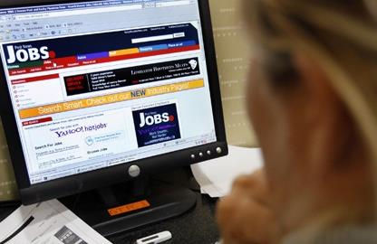 Person searching for a job using a laptop and making career plans at a desk