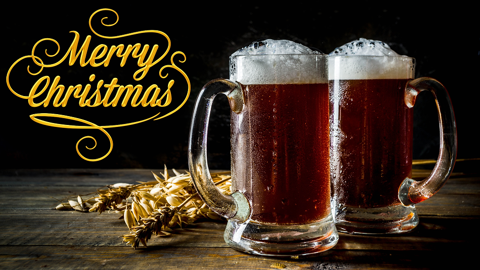 Two mugs of foaming dark Christmas beer on a wooden table, with the words ‘Merry Christmas’ in gold lettering beside them.