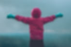 Person standing on a mountaintop in Norway, embracing the view