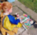 A child painting Easter decorations in the garden