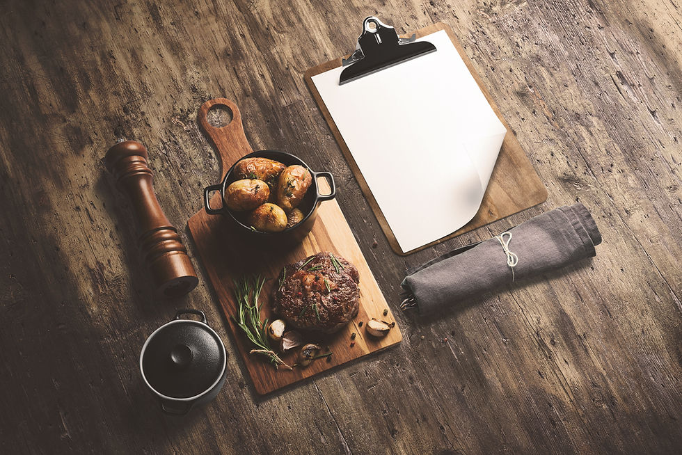 Steak on wooden serving board, with baked potatoes in a pot and sauce, with cliboard menu
