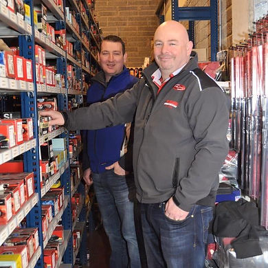 Image shows shop owners in front of shelving