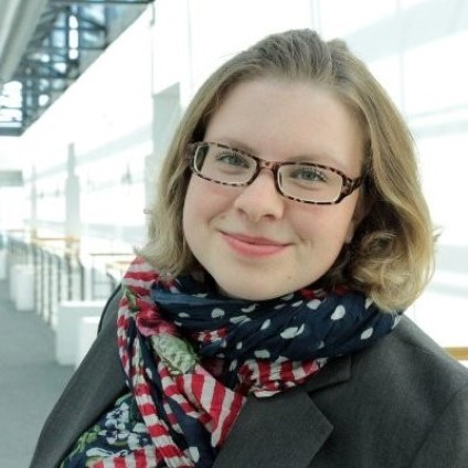 Porträt einer lächelnden Frau mit Brille und Schal
