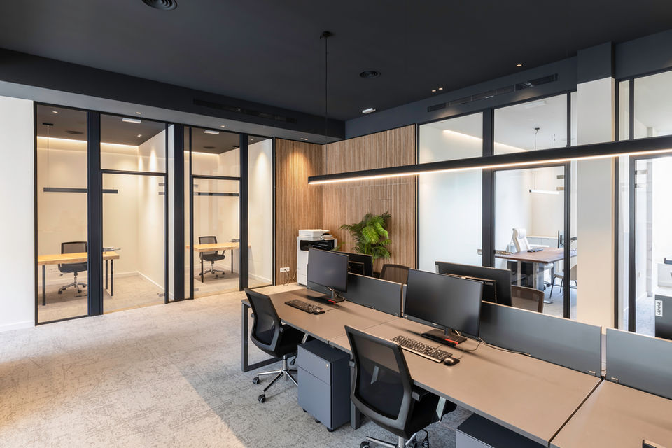 Sala de trabajo y despachos en oficina moderna de Barcelona.