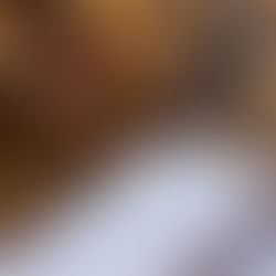 A cozy scene with an open Bible and floral mug on a sofa, set against a background of blurred warm lights, evoking a peaceful mood.