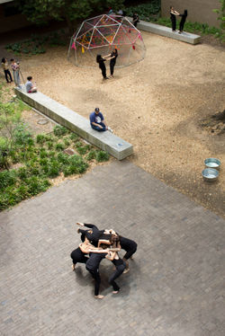 Image: Artists huddled together with other artists performing in duets