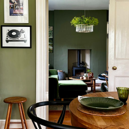 A view through two green living spaces, light into dark