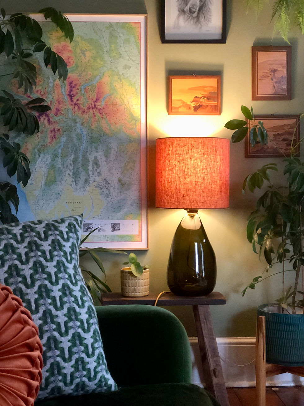 Warm glow of an amber lamp lighting up a gallery wall in a green room