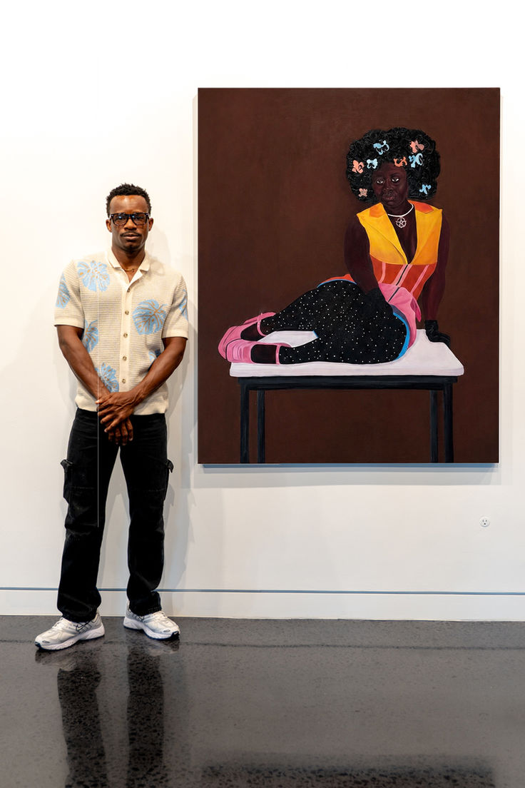 Artist standing beside Presence II portrait in a gallery