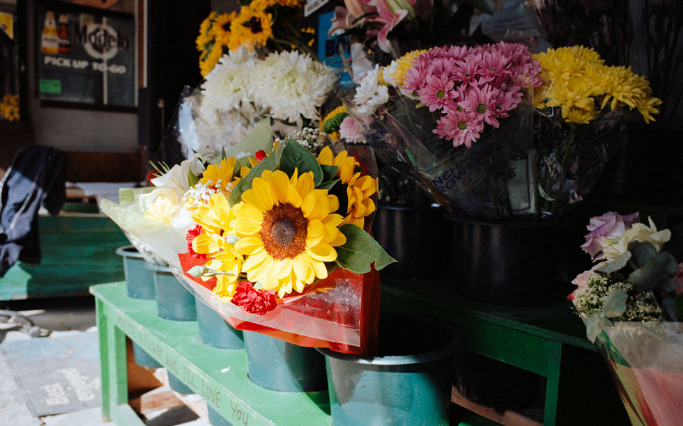 Bouquet of flowers displayed in pots on shelves.