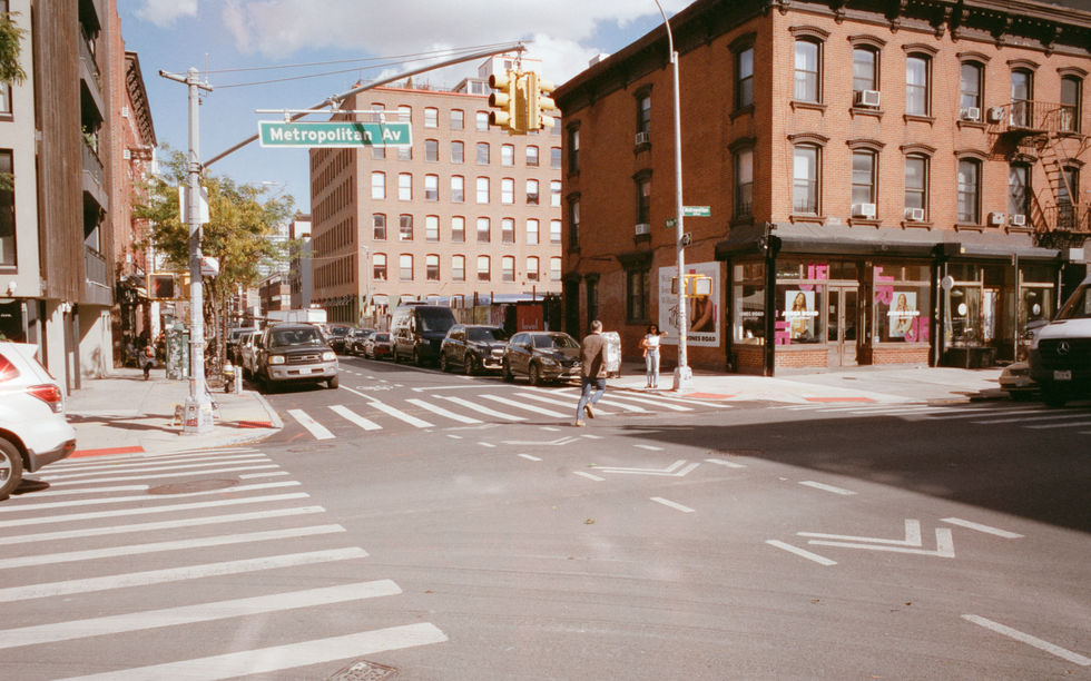 Street corner with brick buildings and crosswalk.