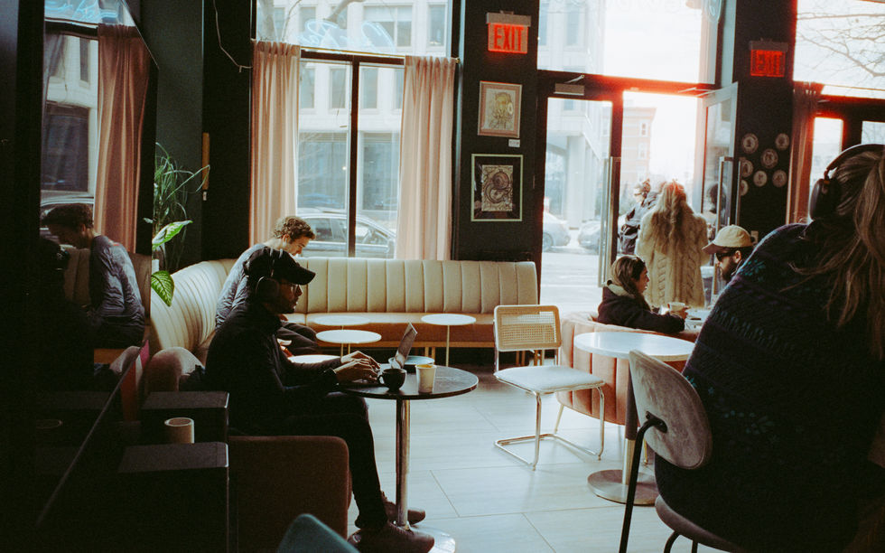 Cozy cafe with people working on laptops.