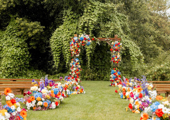 A wedding altar draped in brightly colored floral arrangements