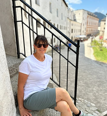 Female sitting on stone steps while visiting a landmark in Europe