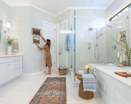 Serene white bathroom with soaking tub and vintage rug by Samantha Kate Design