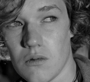 Standbild aus dem Filmtrailer. Schwarz-weiss Nahaufnahme eines Mannes (Gesicht)