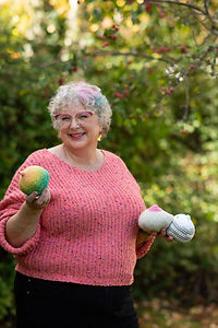 A woman posing and holding some knitted breasts