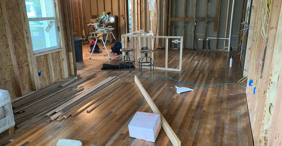 Flooring and new space taking shape. Walls not yet insulated and kitchen island framework set in place.