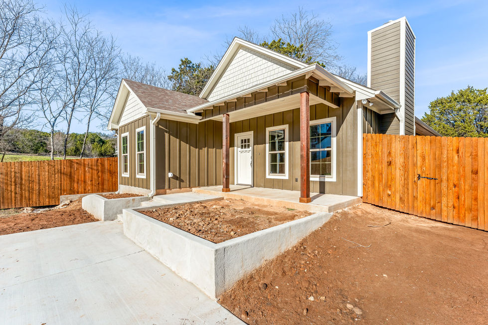 a brown and white house with a wooden fence in front of it