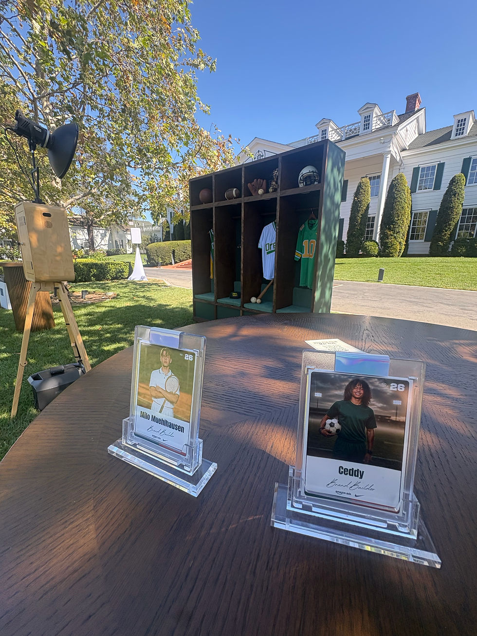 A picture pf trading cards and photo booth set up on a lawn with backdrop