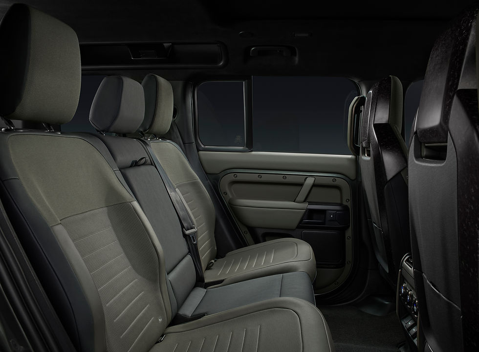 Rear seat of a car with dark gray upholstery and sleek design. No passengers. Interior detail visible with doors and seatbelts. Defender OCTA