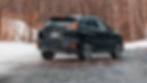Black Mitsubishi Eclipse Cross SUV parked on an icy road, snowy background with bare trees. Car license plate visible: FMV6922.